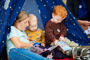 Mother and children reading in a tent