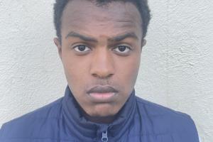 an image of a student (josh) looking into the camera. he is wearing a blue puffer jacket and has a stoic expression on his face. the student is in a neutral white background