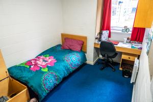 Ffriddoedd classic ensuite room 8.9ms with a bed, desk, chair and shelves
