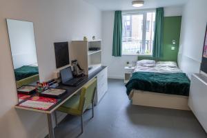 St Mary's Premium En-suite with a bed, desk, shelves and a chair
