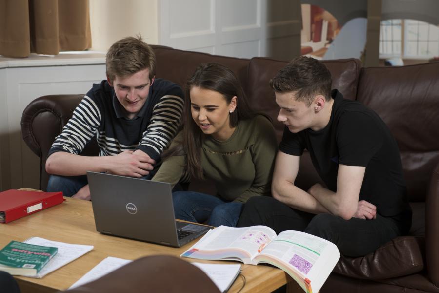 Students looking at a laptop together