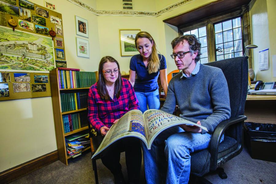 Students and lecturer looking at archives