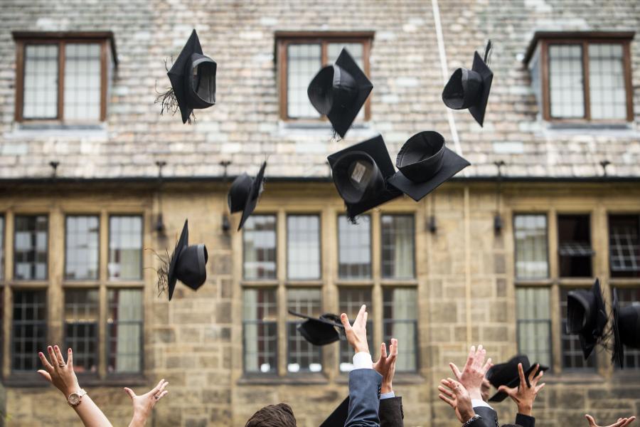 Students celebrating by throwing their caps in the air after their graduation ceremony