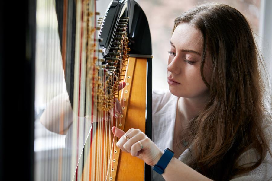 Student playing the harp