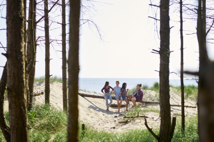 Students sitting on the beach in nearby Llanddwyn
