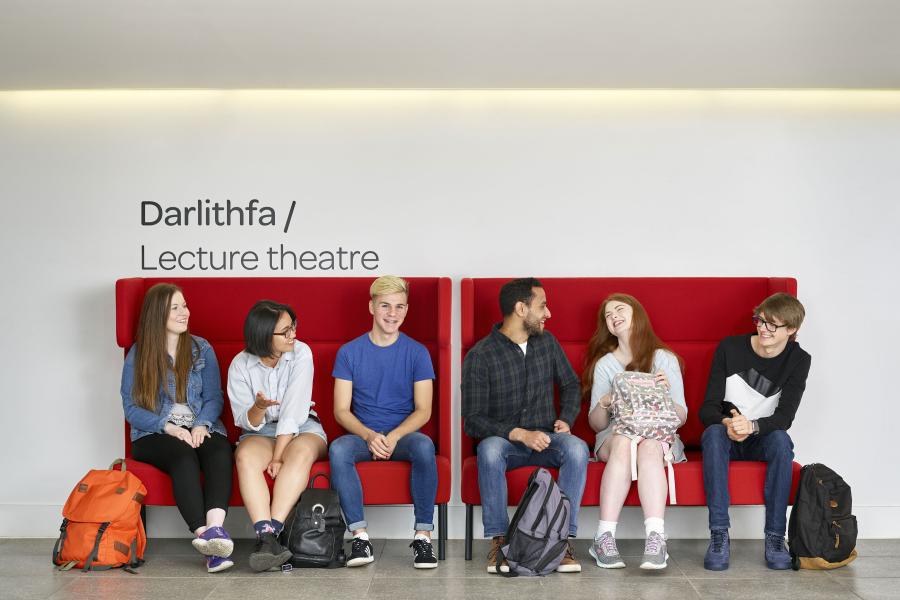 Students sitting outside the Lecture Theatre in Pontio