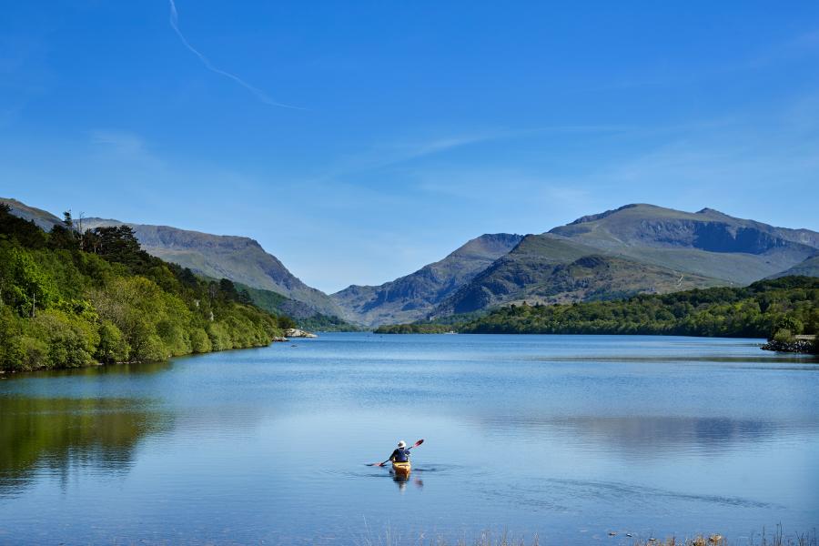 Myfyriwr mewn caiac ar Lyn Padarn yn Llanberis