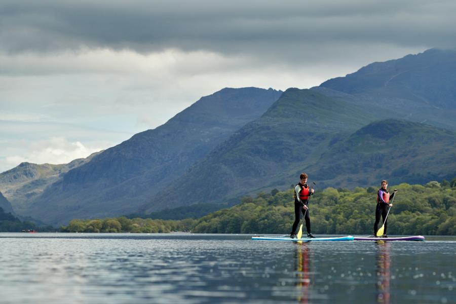 Students paddle boarding on a lake 