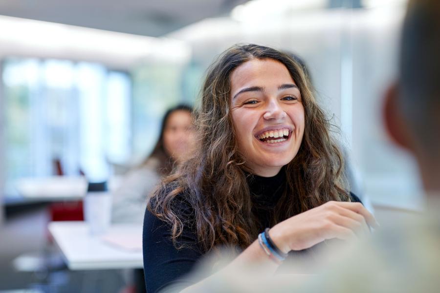 A student laughing while socialising with a friend