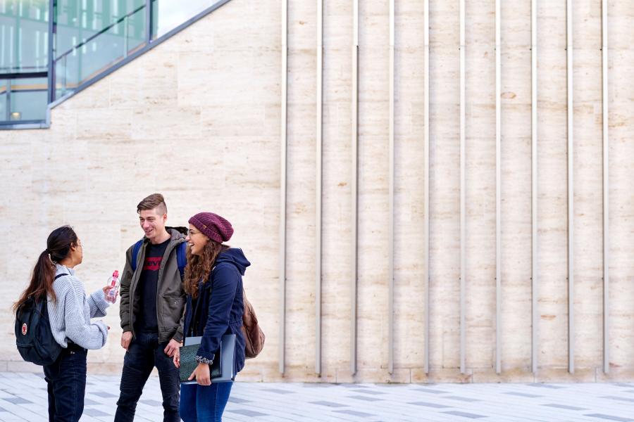 A group of students talking outside Pontio on their way to a lecture