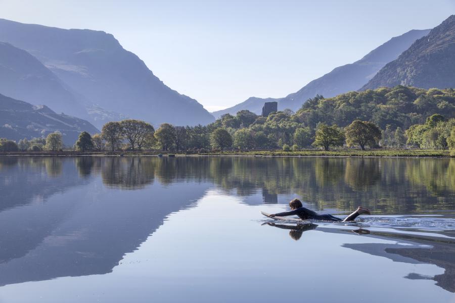 Myfyriwr ar Fwrdd Padlo ar Llyn Padarn yn Llanberis