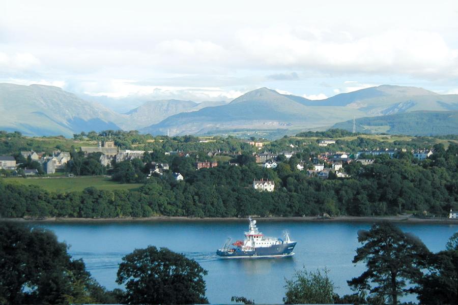 Llong Ymchwil Prifysgol Bangor, y 'Prince Madog', gyda mynyddoedd Eryri yn y cefndir