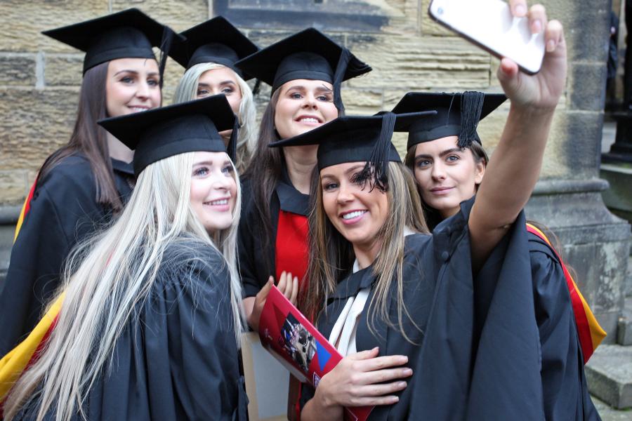 A group of female students in taking a selfie on their graduation day