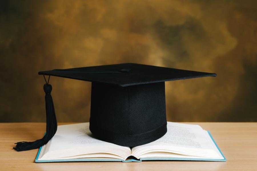 Graduation cap over open book