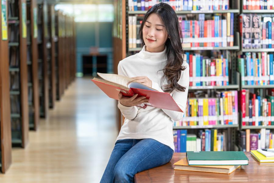 Student reading a book in the library 