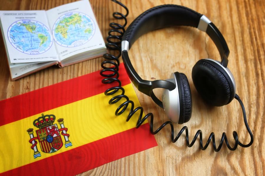 Headphones and book with a Spanish flag on a desk.