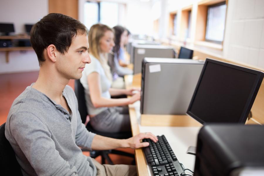 Row of students working in a computer room