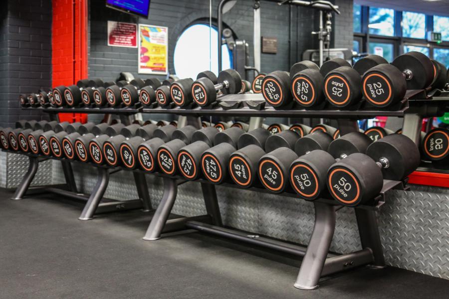 Weights lined up at the side of the gym at Canolfan Brailsford