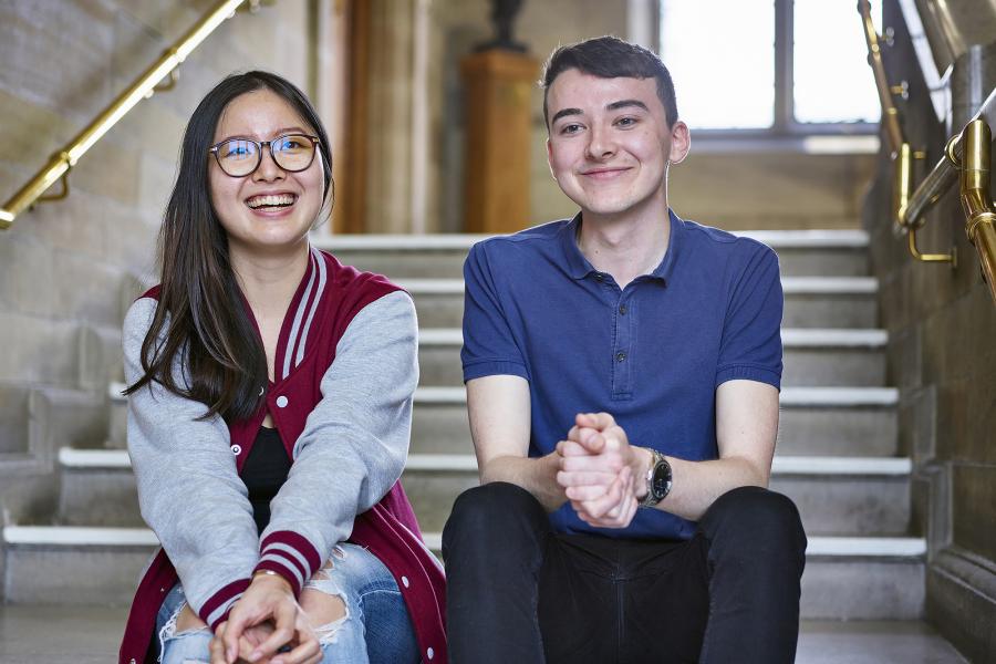 Two students sitting on the stairs in the Main Building