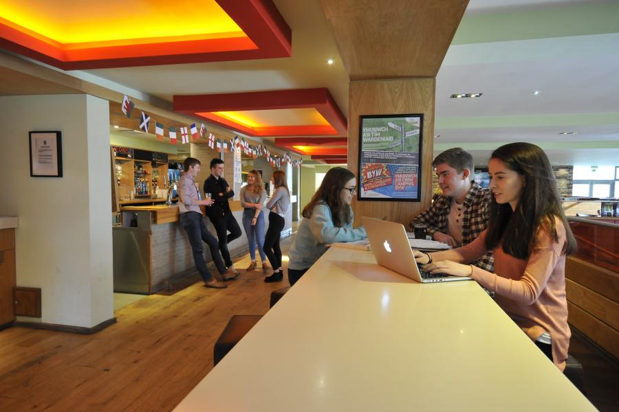 Students studying and relaxing at Bar Uno, Ffriddoedd Student Village