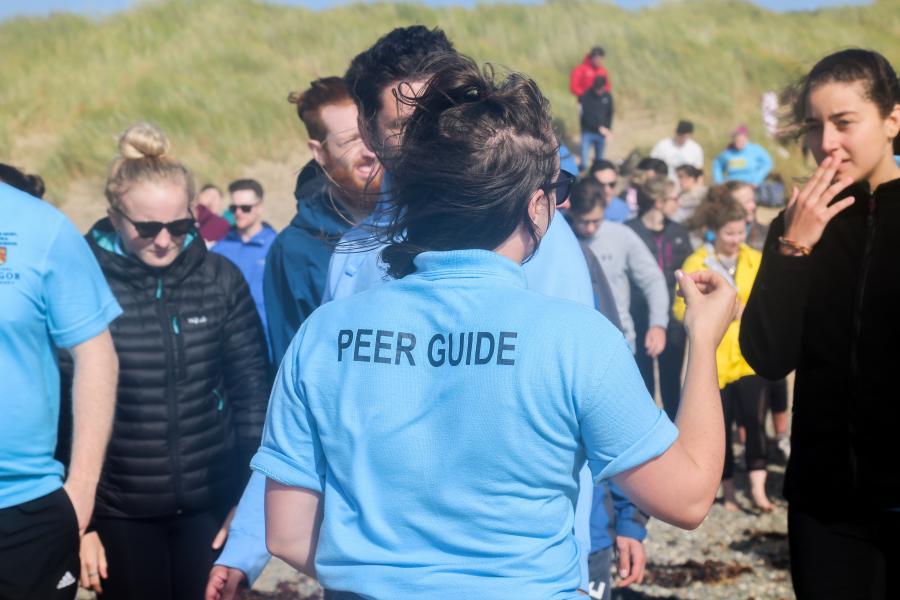 Peer guides helping students on a welcome week activity at the beach