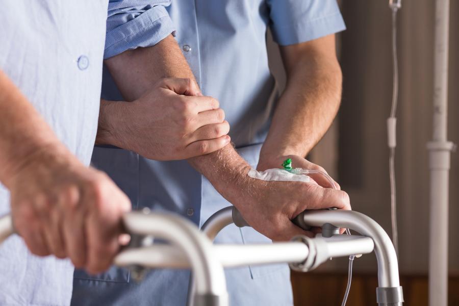 Health care nurse providing support and care to an elderly gentleman