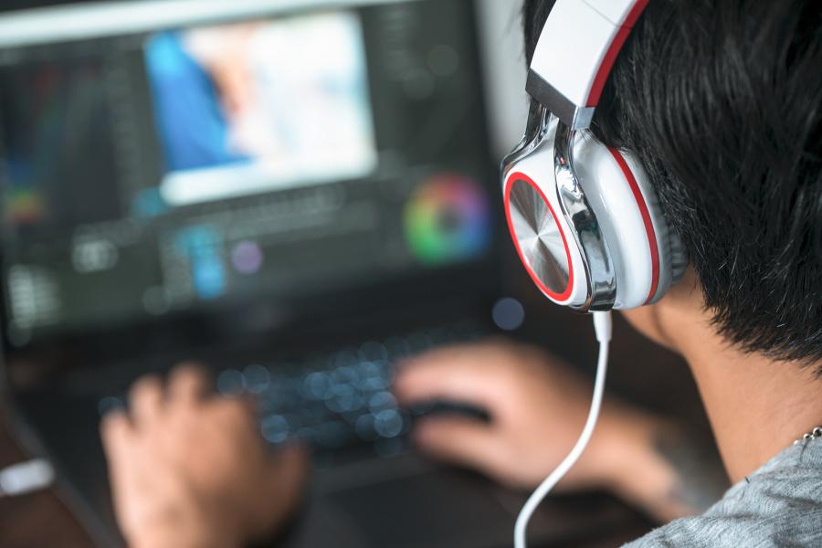 student wearing headphones editing media