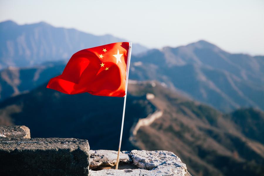 China flag flying over mountains in China