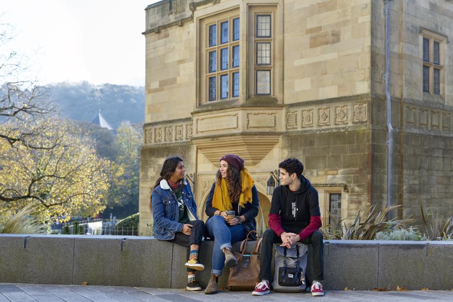 Students sitting in front of Bangor University's Memorial Arch