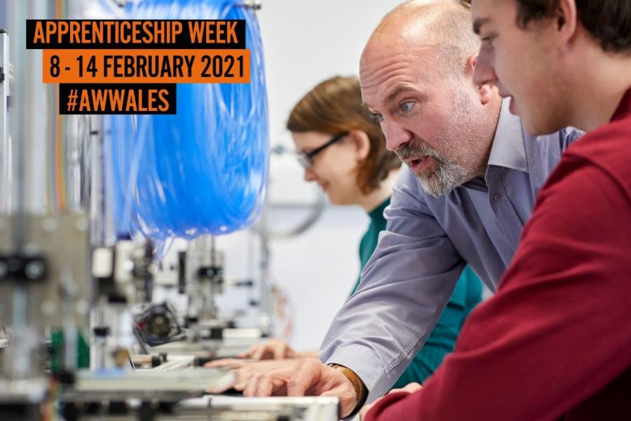 Lecturer and young person looking at equipment with Apprenticeship Week logo at top left