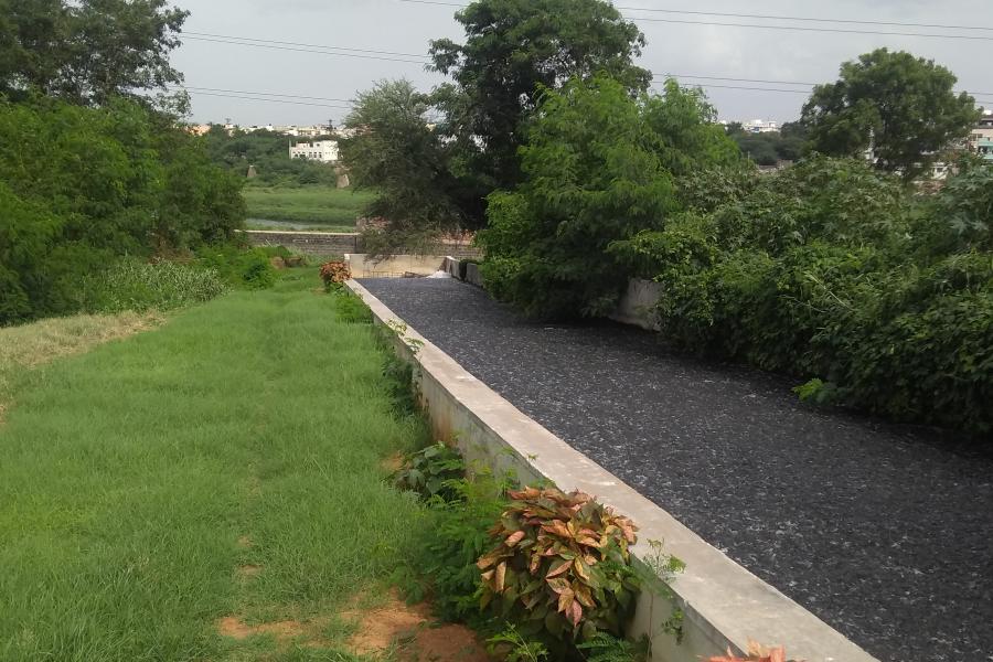 Landscape dividied into hardcore area and area of grass with concrete boundary between them.