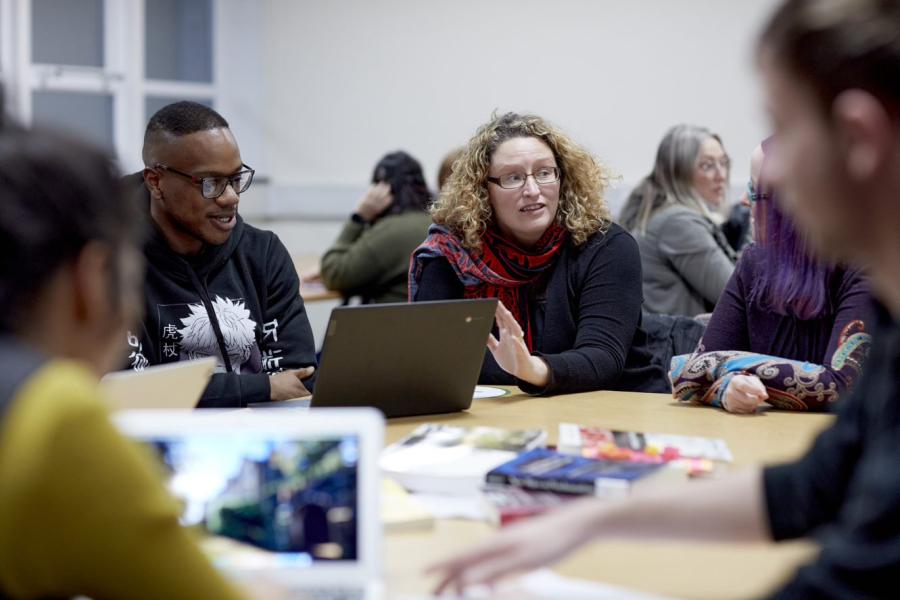 A group of people sit around a table working