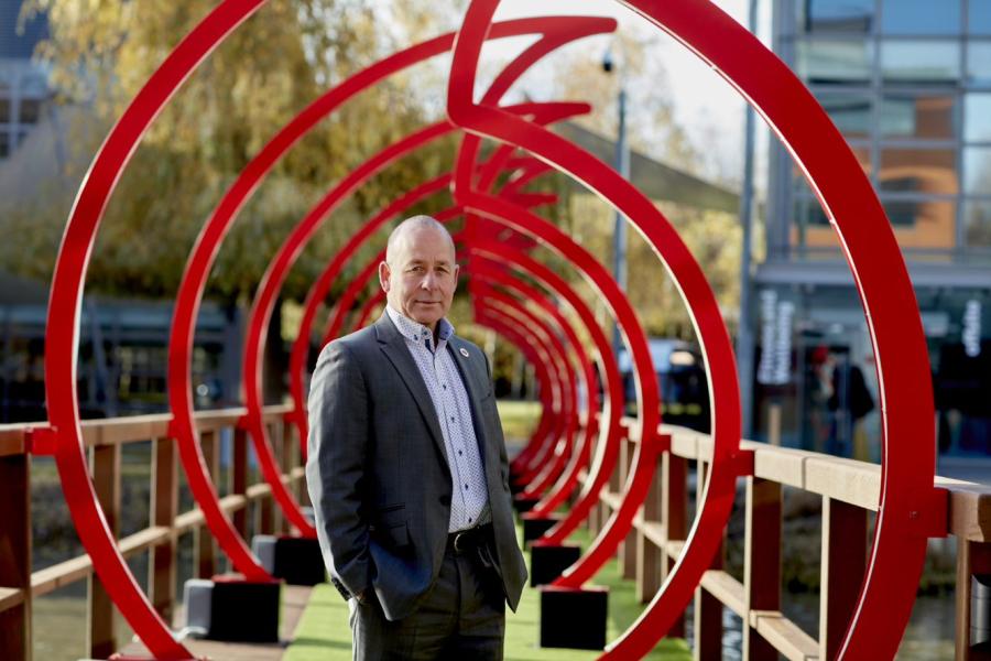 Paul Morton of Vodafone outside, standing on a bridge shaped as the Vodafone logo