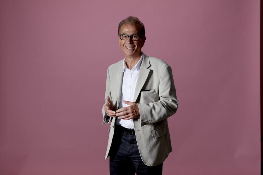 Askar Sheibani, Group CEO ofComtek Network Systems (UK) Ltd, stands in front of pink background