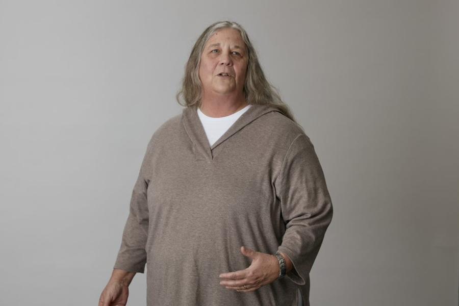 Dr Shelagh Malham stands in front of grey background