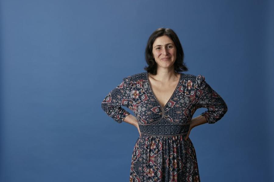 Dr Eirini Sanoudaki stands in front of blue background