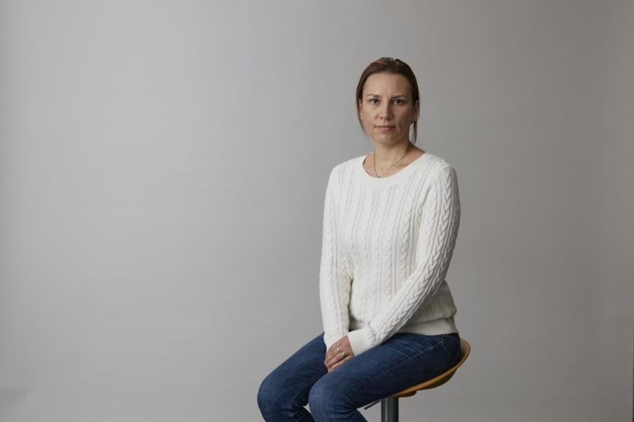 Kata Farkas sits in front of grey background