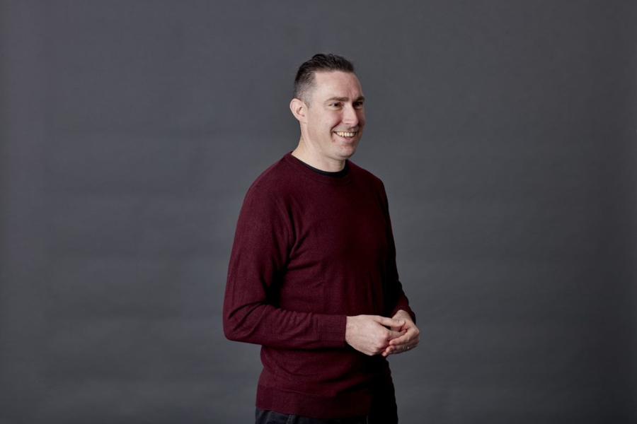 Kevin Deyna-Jones of Bangor University stands in front of a grey background