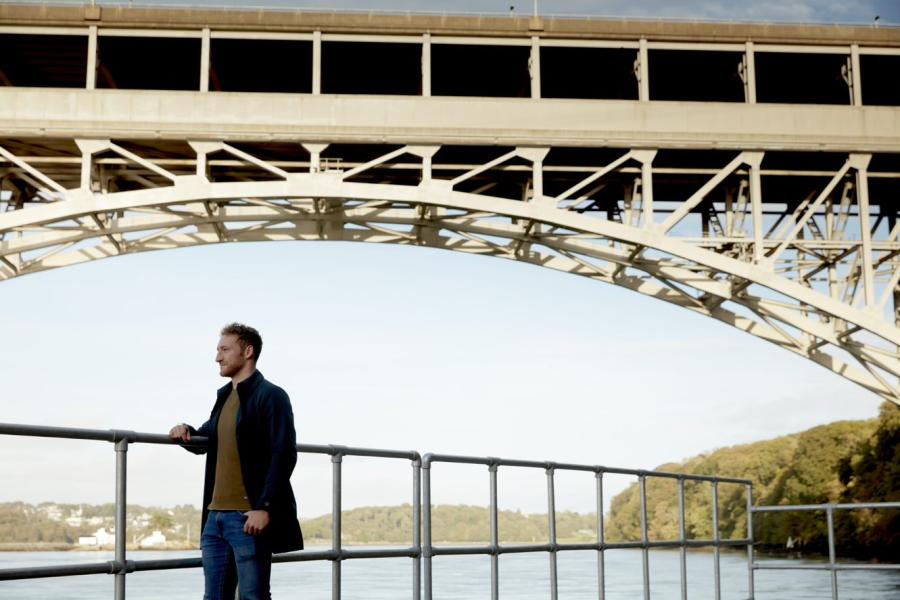 A male student standing by Brittania Bridge