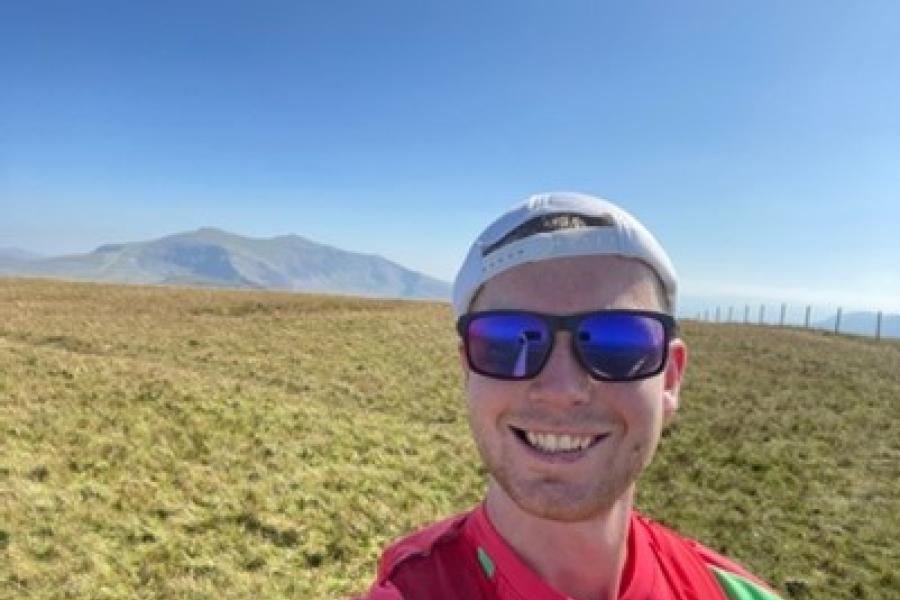 Smiling face with sunglasses and  baseball cap reversed- on some hills