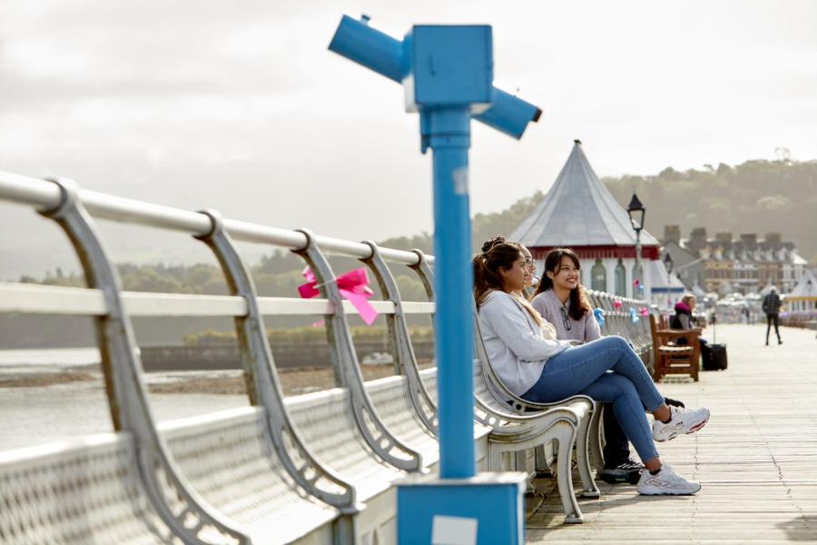 Students sitting on benches on Garth Pier