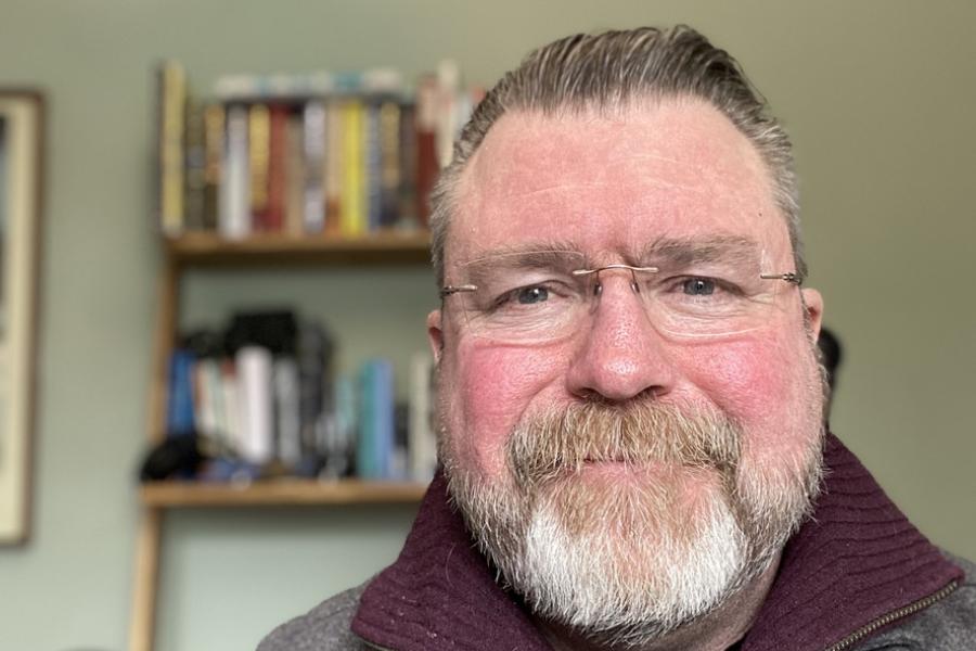 Prof Paul Mullins with a bookcase behind