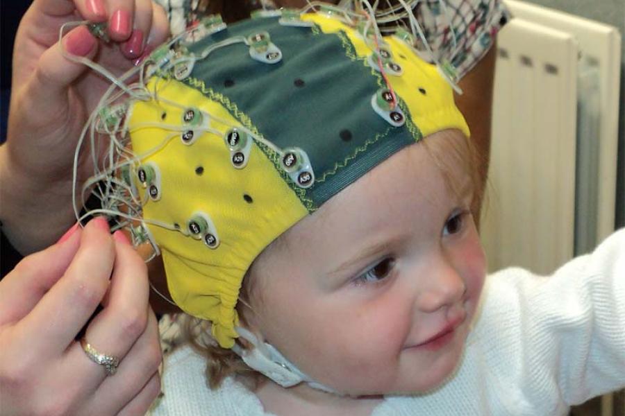 Baby with an electrode cap for EEG test