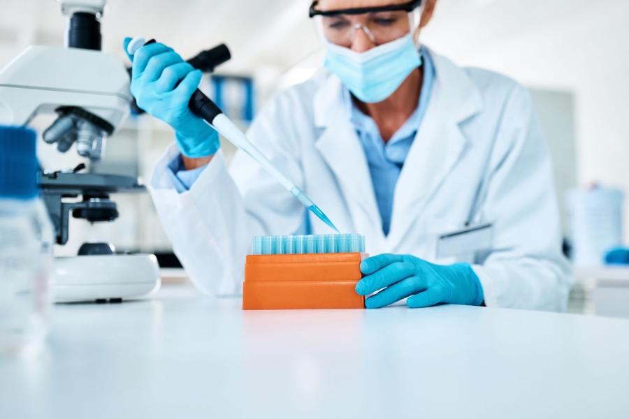 A woman in a white coat tesing in a lab
