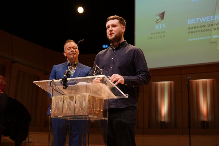 Matt Evans receiving his award on stage