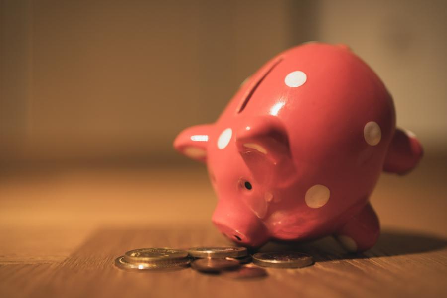 A tilted piggy bank with money