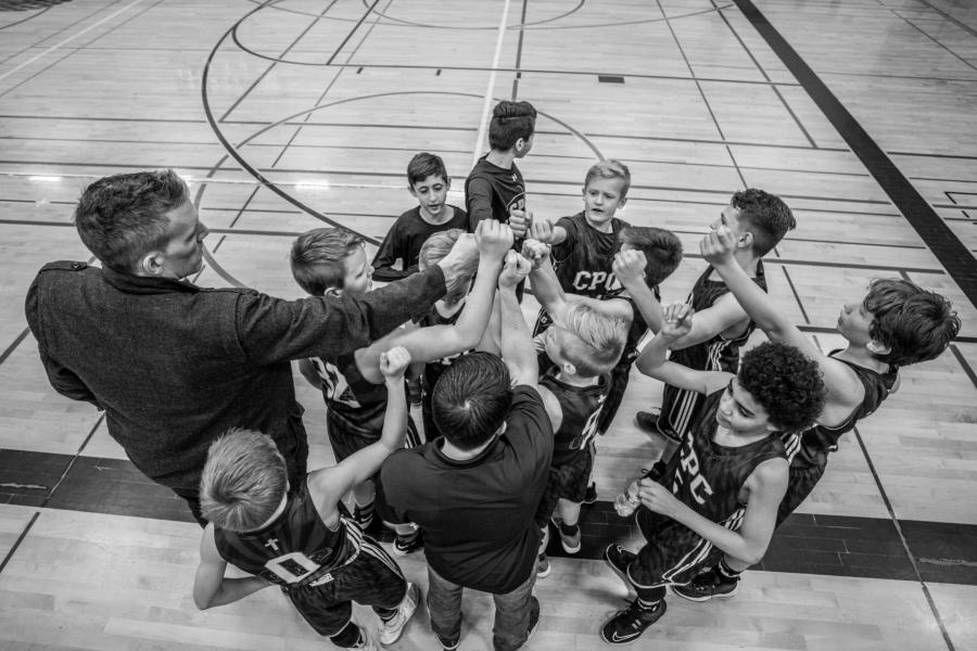 a black and white image of a group kids basketball team with a coach