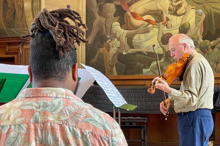 person listening to a musician playing a Viola