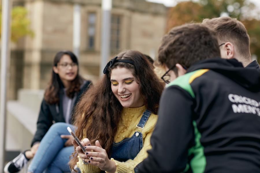 Students socialising and looking at phone