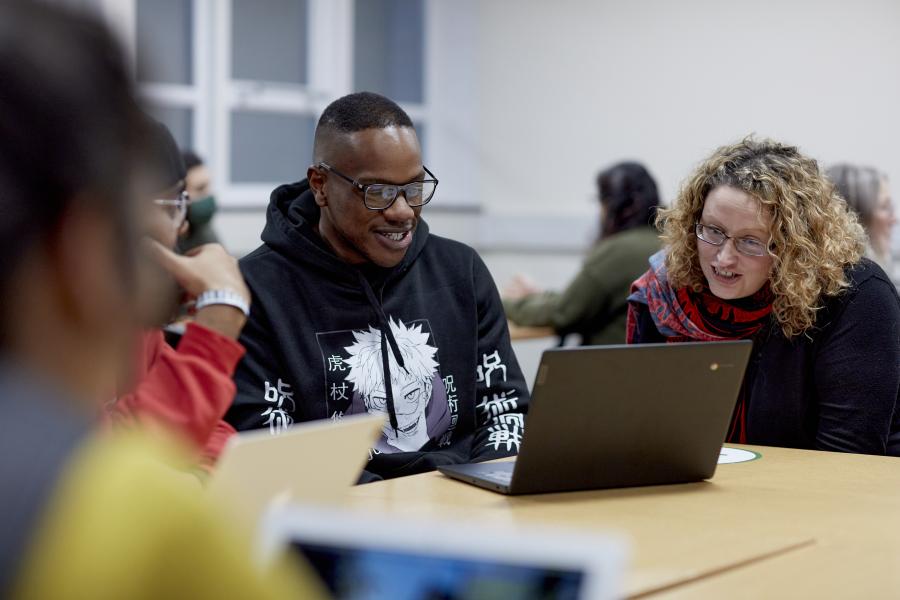 Students studying at table with laptop